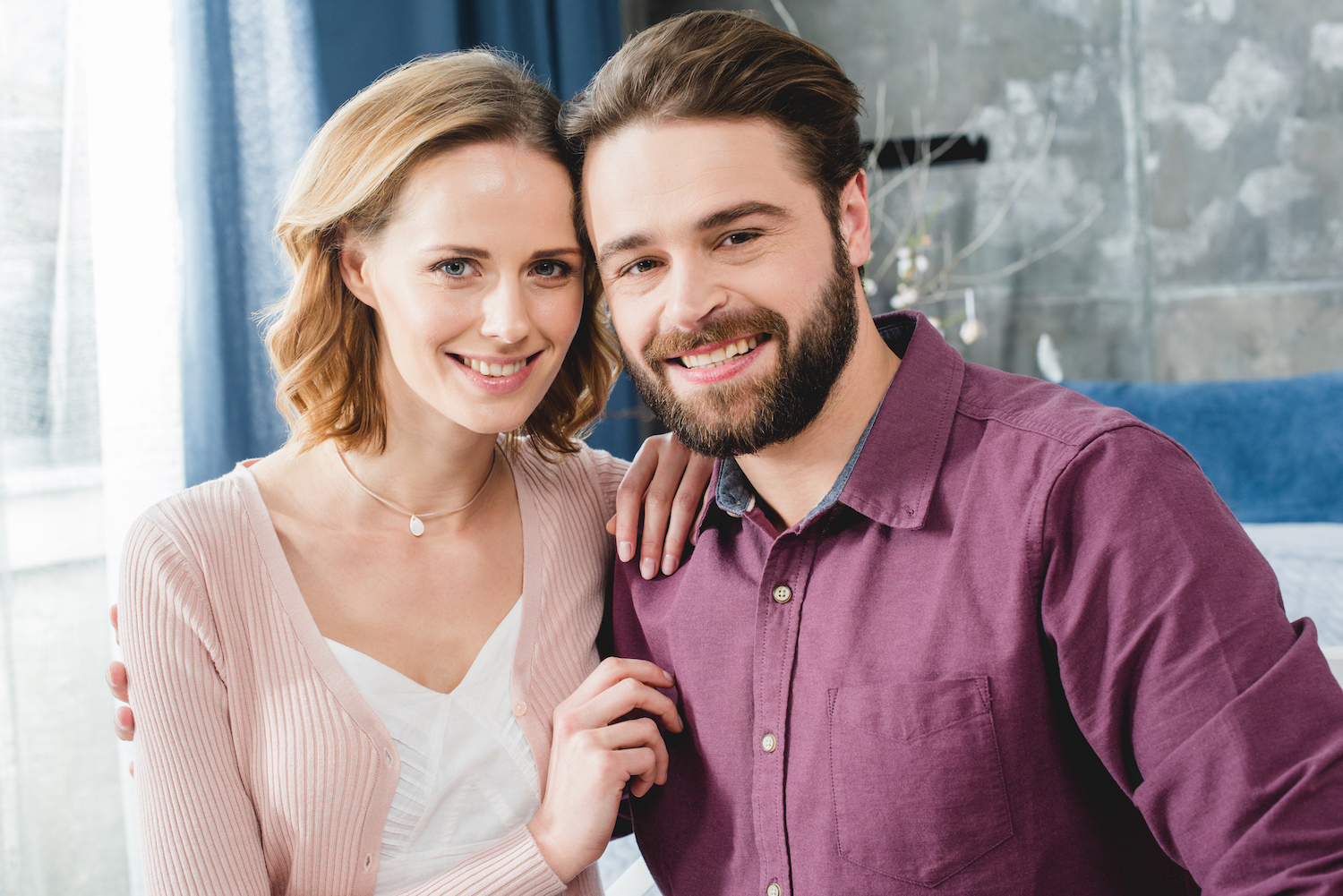 Jeune couple magnifique assis, s'enla&ccedil;ant et souriant