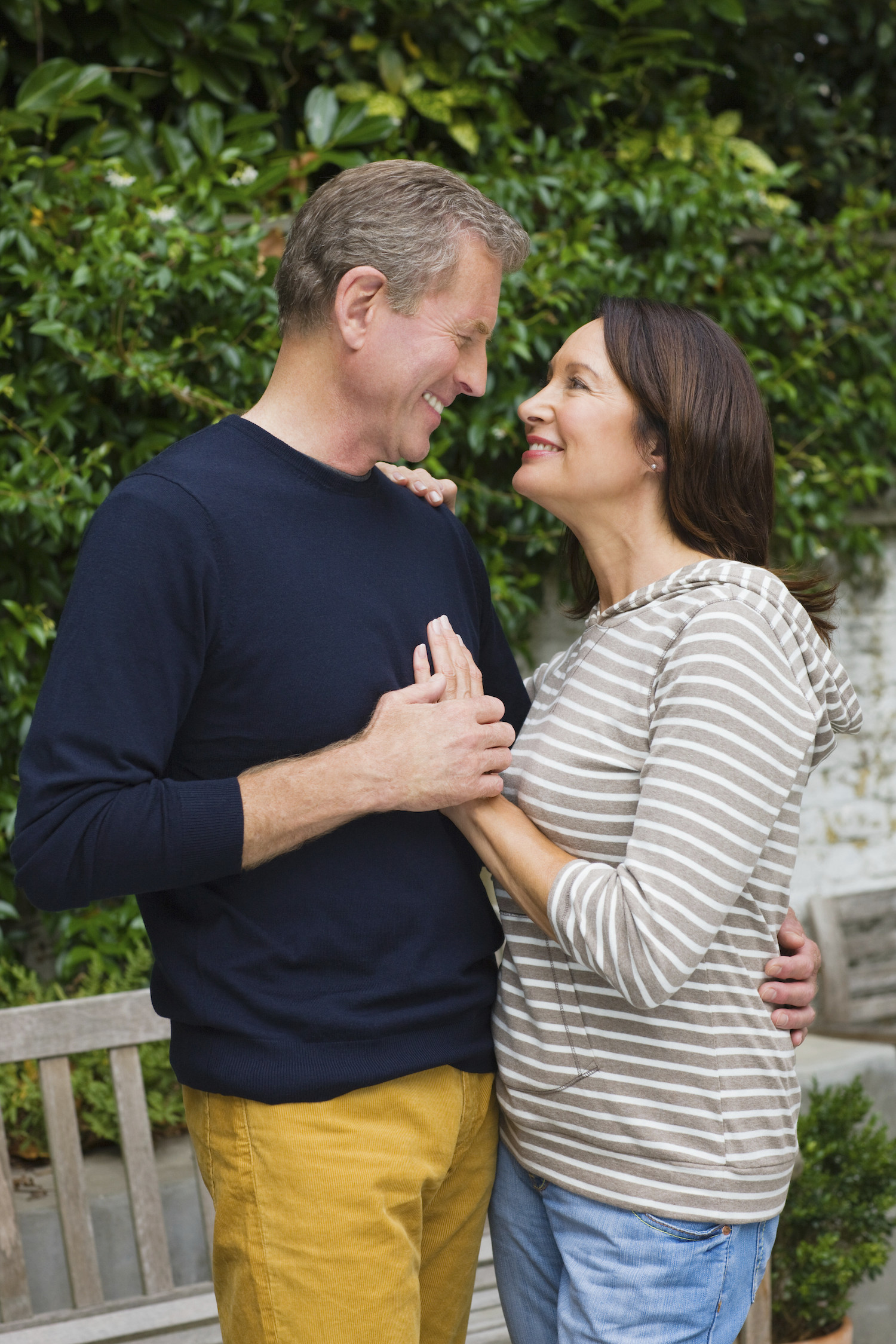 Couple de plus de 45 ans partageant un moment tendre dans un jardin